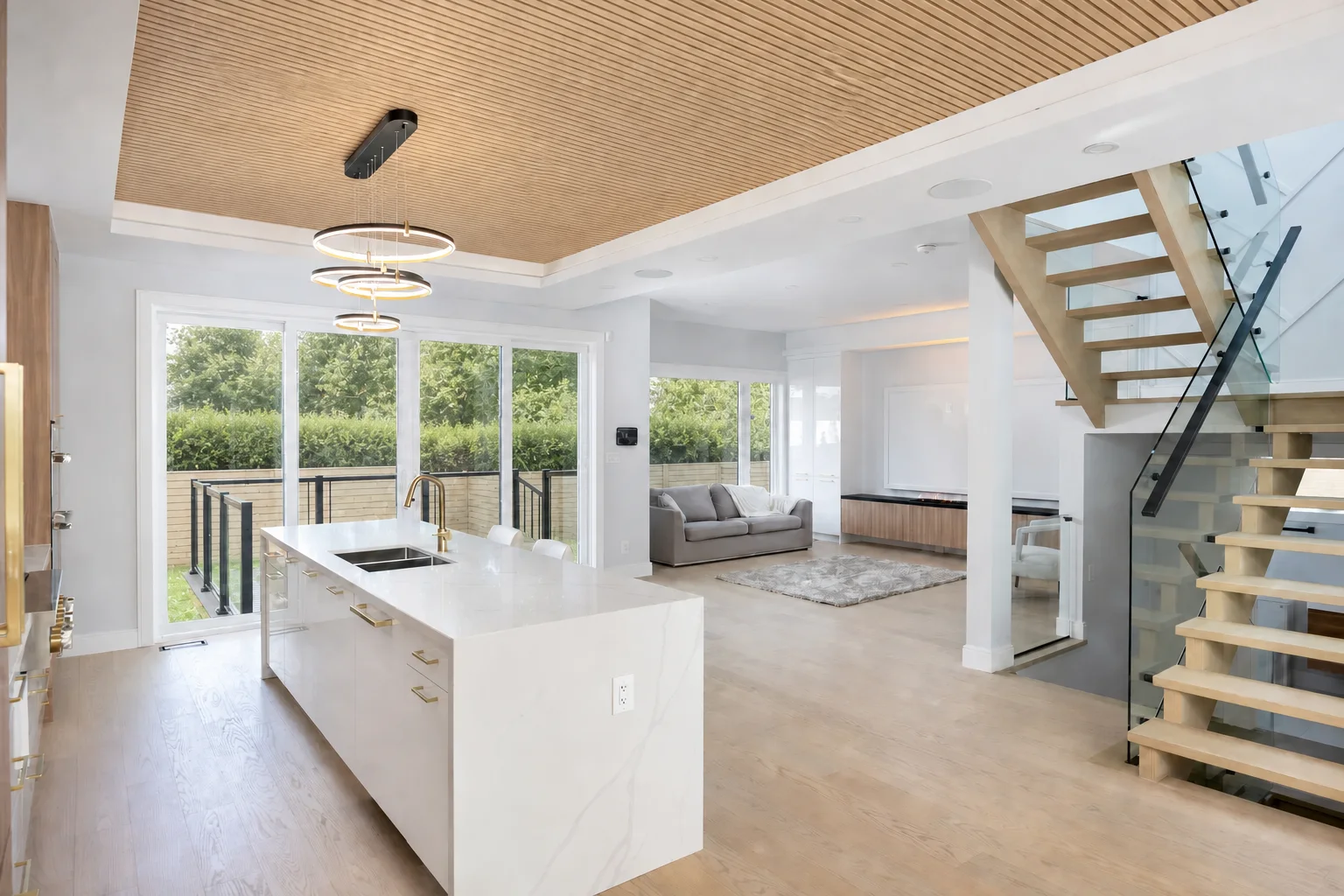 Coordinated renovation project with kitchen cabinetry, living room millwork, wood ceiling treatment, and staircase