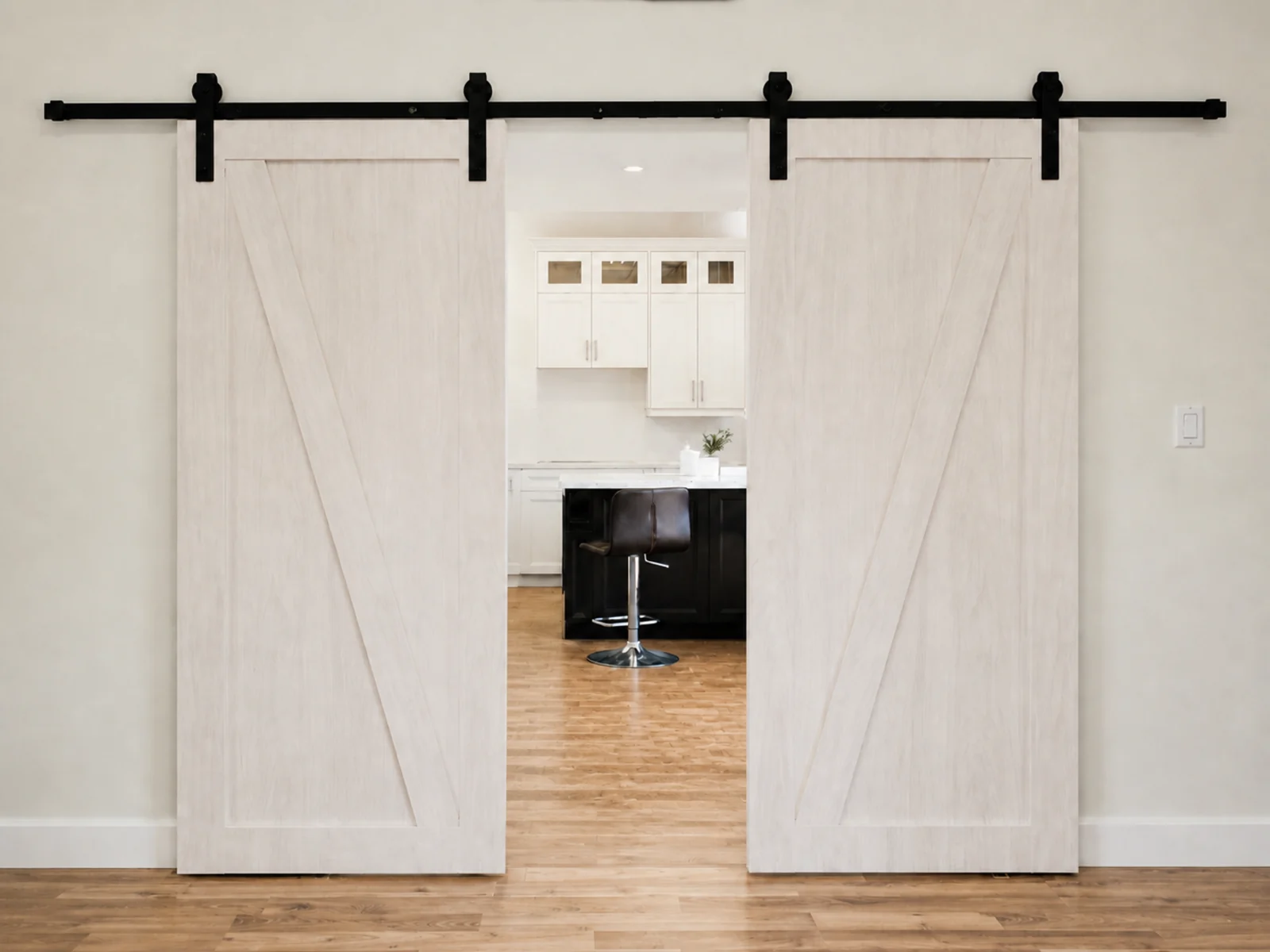 Matching light wood barn-style sliding doors with diagonal trim and a complete exposed black rail.